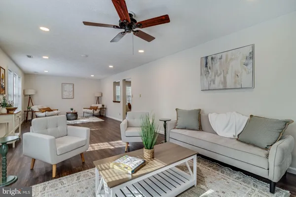 a living room with furniture and a ceiling fan