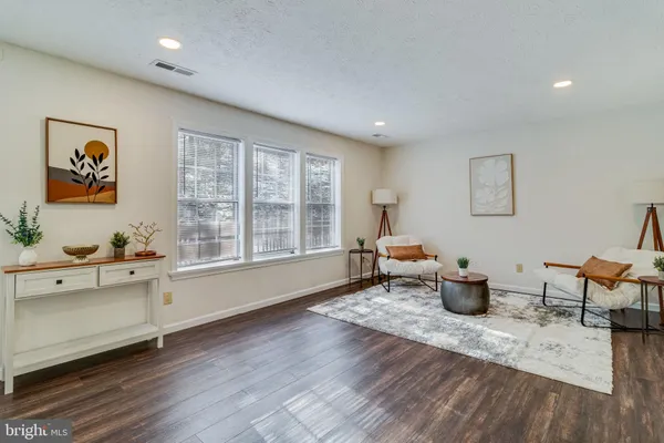 a living room with furniture a window and wooden floor