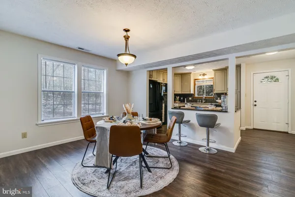 a dining room with furniture a chandelier and wooden floor