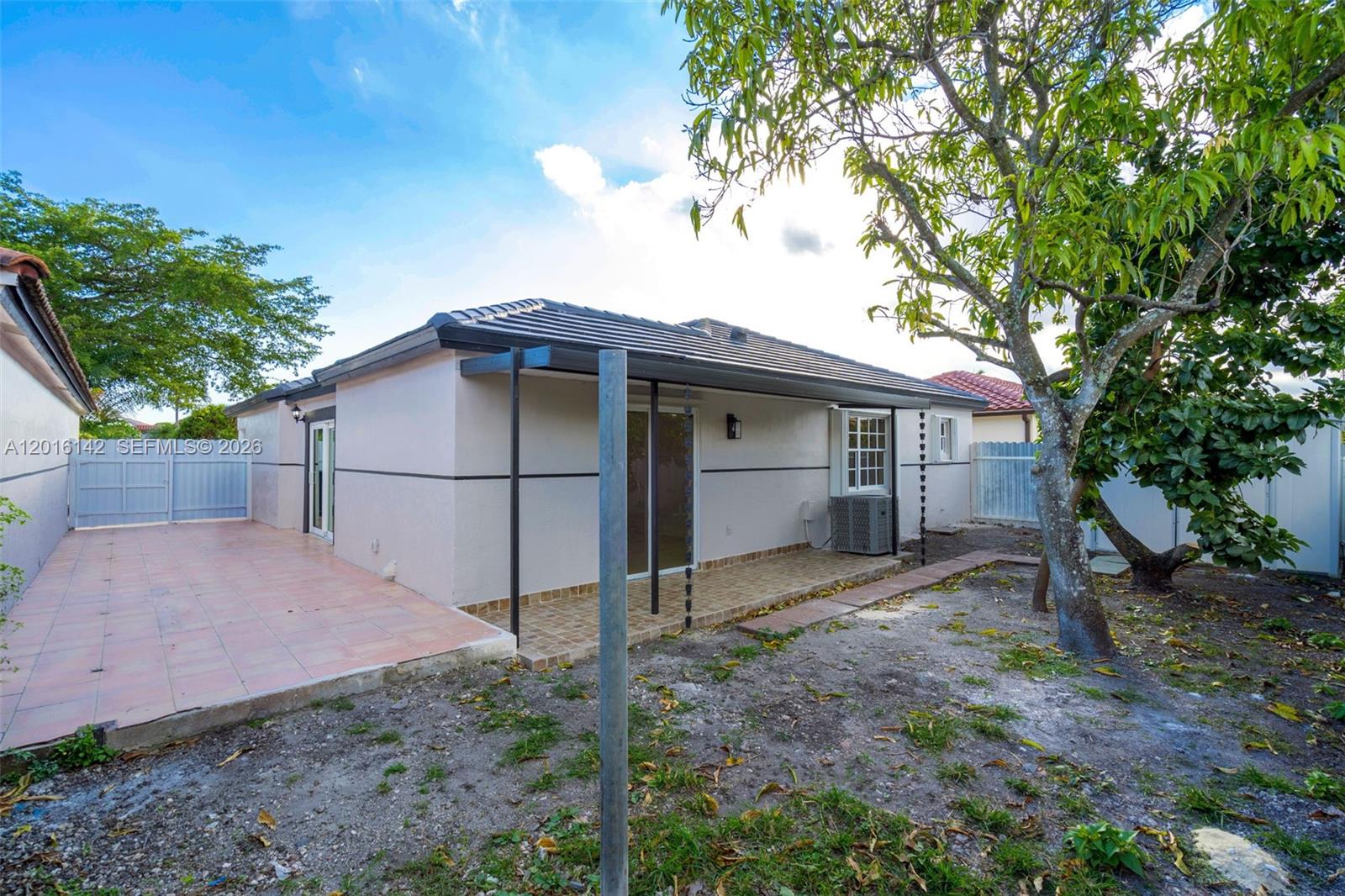 14755 Southwest 82nd Terrace Miami, FL 33193 - Photo 29 of 32 a backyard of a house with wooden fence and large trees