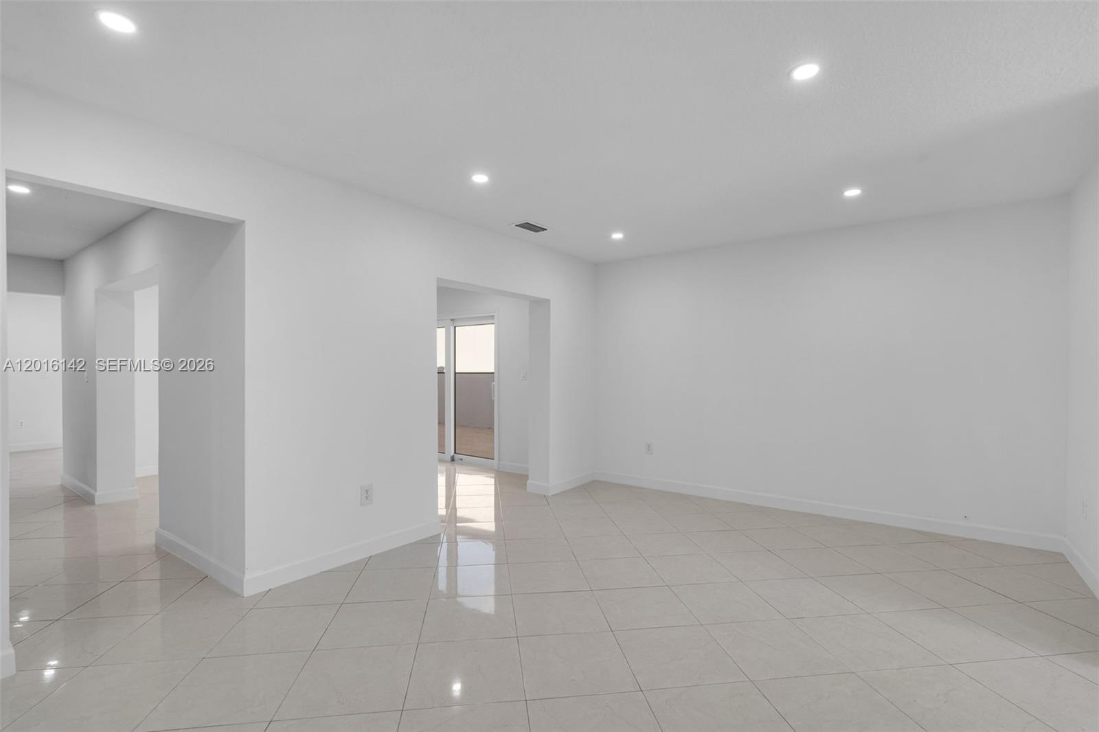 14755 Southwest 82nd Terrace Miami, FL 33193 - Photo 7 of 32 an empty room with windows and entrance to other room