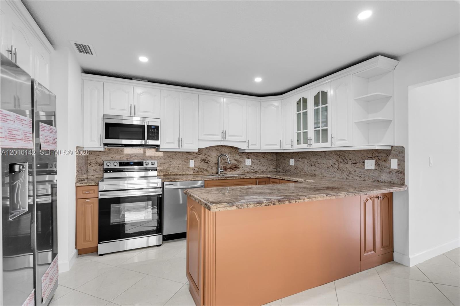 14755 Southwest 82nd Terrace Miami, FL 33193 - Photo 10 of 32 a kitchen with stainless steel appliances granite countertop a stove top oven a sink and dishwasher