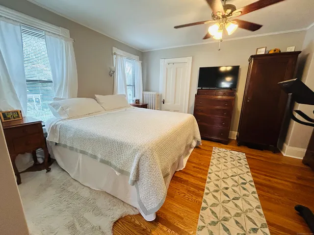 a bedroom with a bed and wooden floor