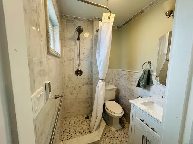 a bathroom with a granite countertop sink toilet and shower