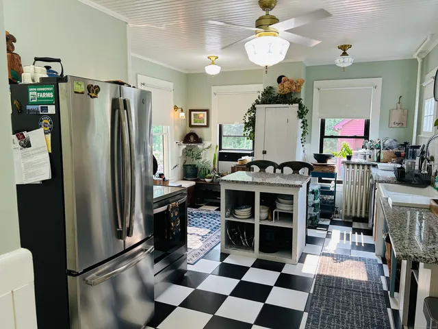 a kitchen with stainless steel appliances granite countertop a refrigerator a stove and a sink with granite countertops