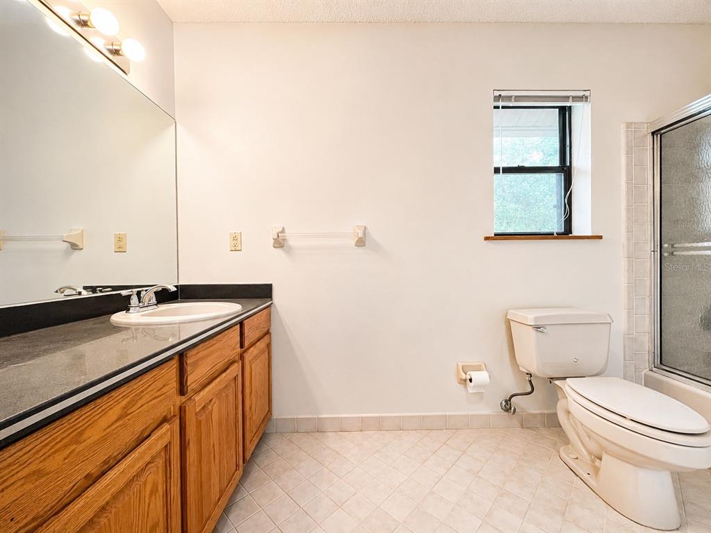 7119 Immokalee Road Keystone Heights, FL 32656 - Photo 27 of 50 a bathroom with a granite countertop sink mirror vanity and toilet