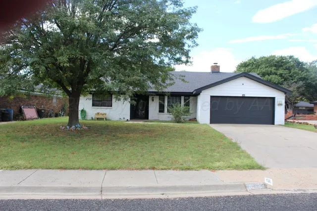 a front view of a house with a garden and trees