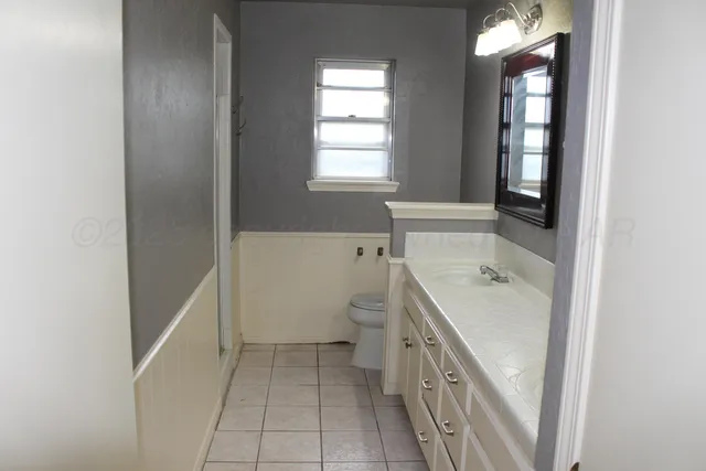 a bathroom with a sink a toilet and window