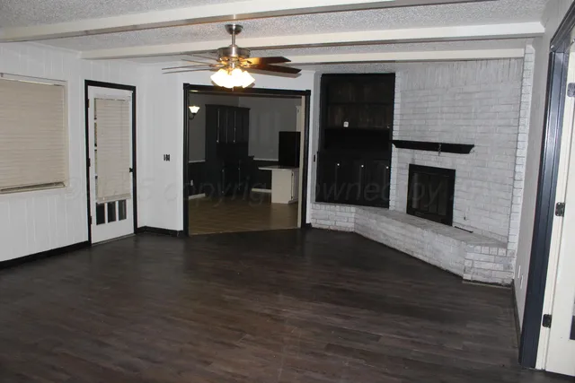 a view of a livingroom with wooden floor a fireplace and window