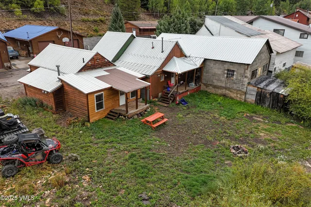 an aerial view of a house with swimming pool and garden
