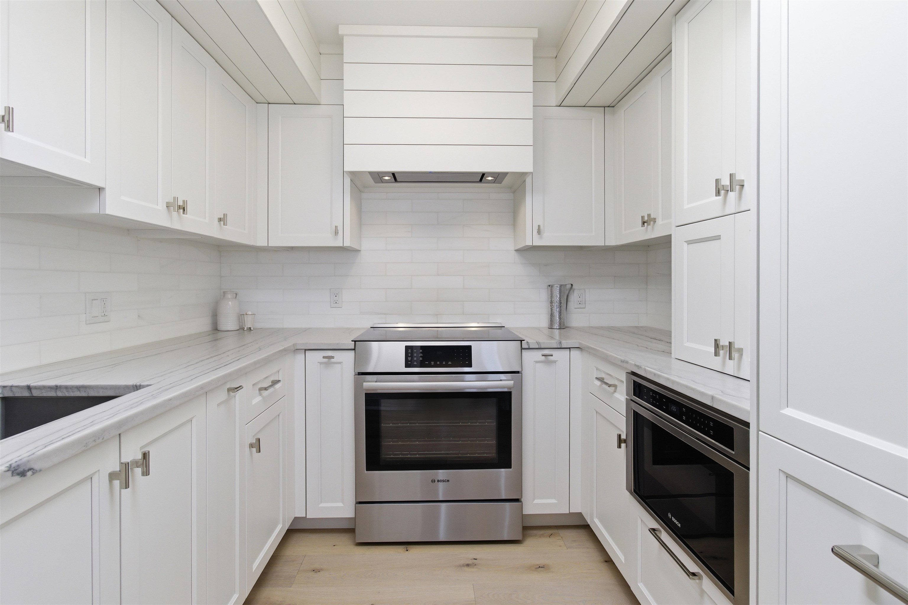 10803 3rd, Unit 6 Stone Harbor, NJ 08247 - Photo 15 of 25 a kitchen with white cabinets and white appliances