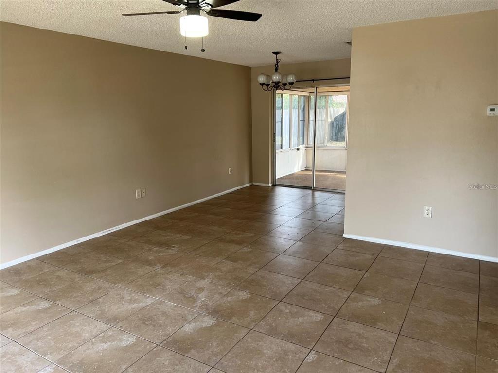 3350 Van Nuys Loop New Port Richey, FL 34655 - Photo 2 of 10 an empty room with a chandelier fan and windows