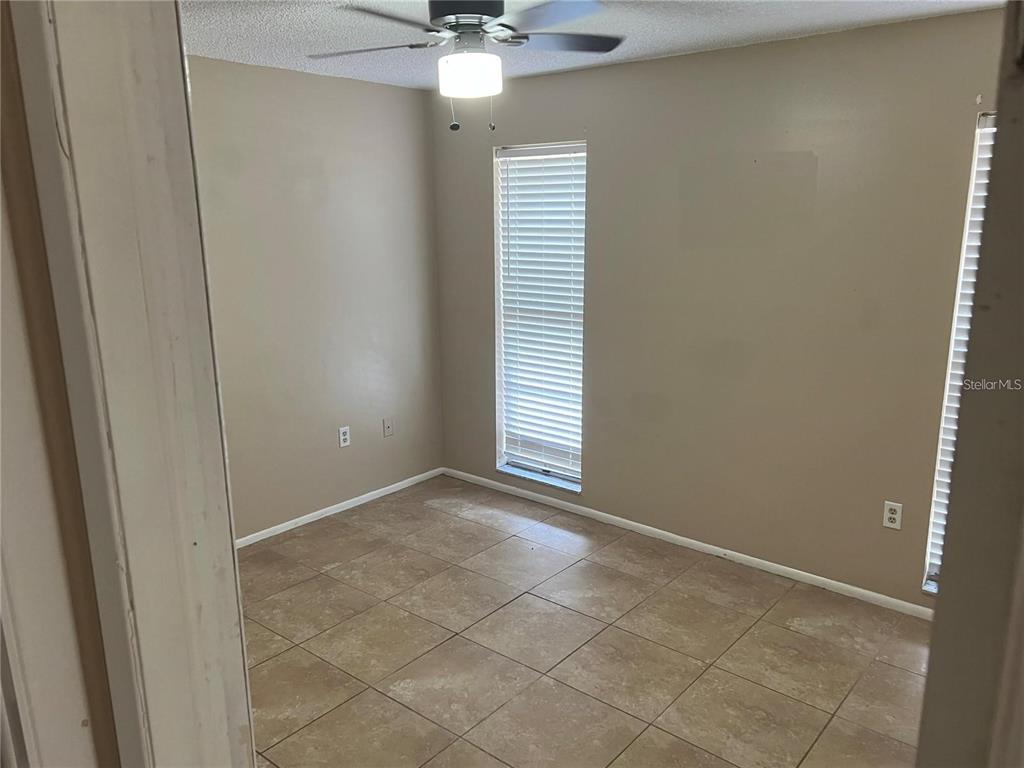 3350 Van Nuys Loop New Port Richey, FL 34655 - Photo 3 of 10 an empty room with a window and chandelier fan