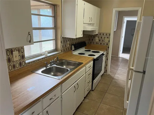 a kitchen with a sink stove and refrigerator