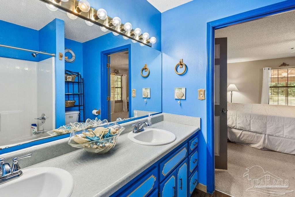 8938 Pioneer Road Holt, FL 32564 - Photo 21 of 44 a bathroom with a sink double vanity and a mirror