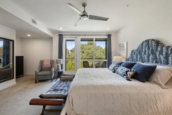 a bedroom with a bed a couch and a large window