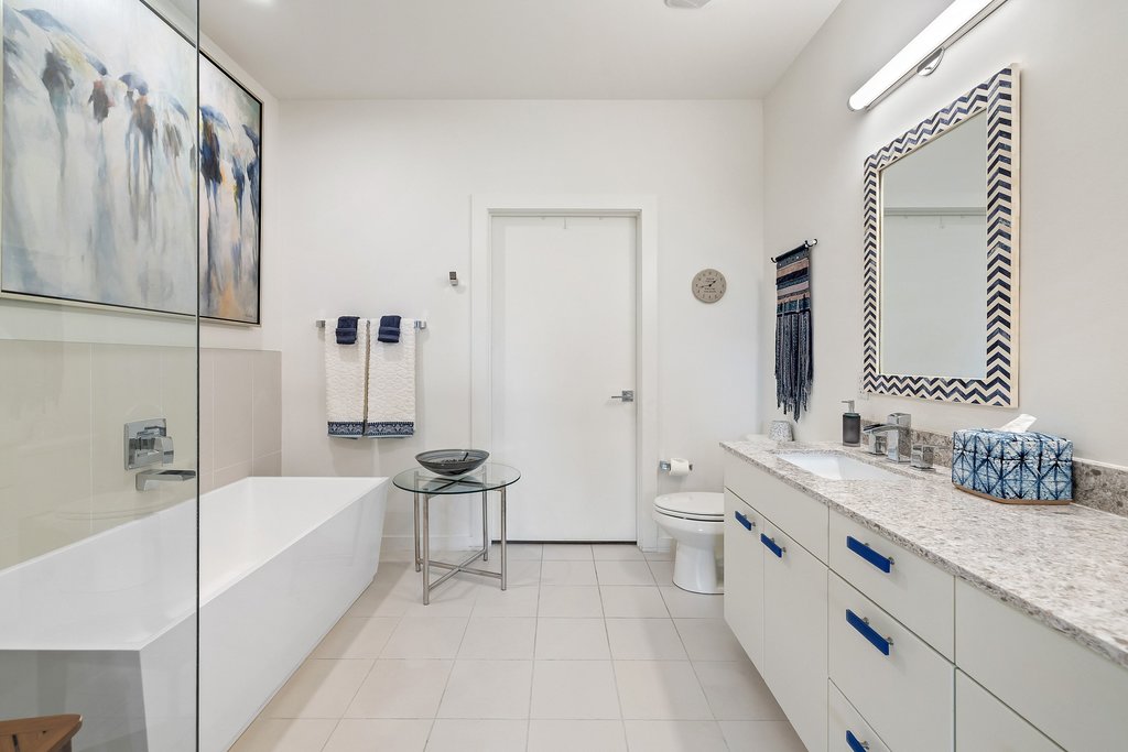 2003 Wilson Street, Unit 3 Austin, TX 78704 - Photo 15 of 27 a bathroom with a granite countertop double vanity sink a mirror and a bathtub