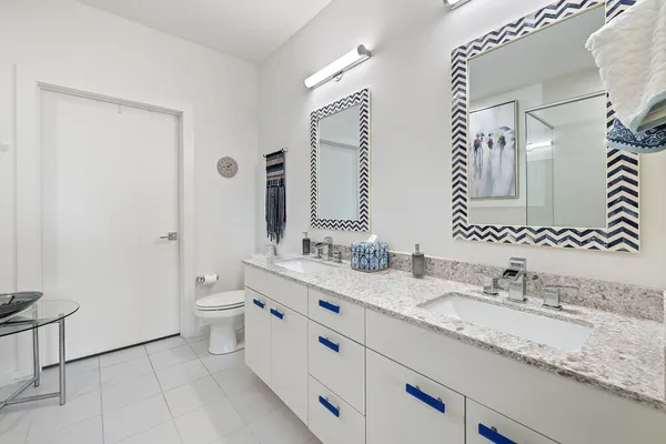 a bathroom with a granite countertop sink mirror vanity and toilet