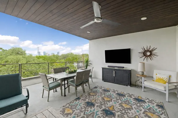 a living room with furniture a flat screen tv and a floor to ceiling window