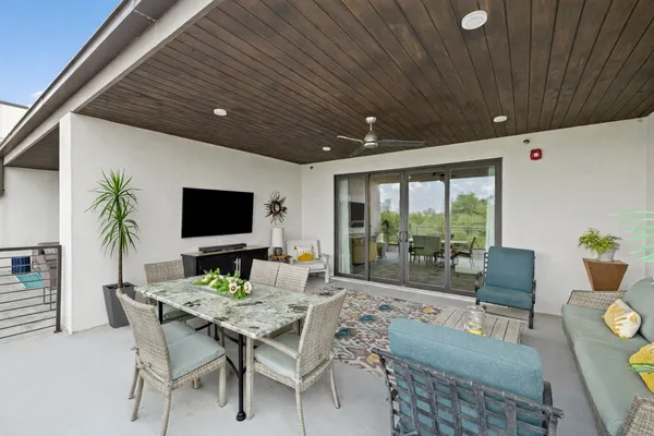 a living room with furniture a flat screen tv and a large window