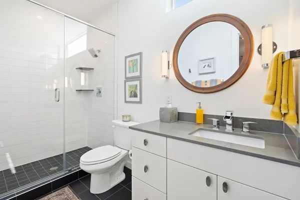 a bathroom with a granite countertop toilet a sink and a mirror