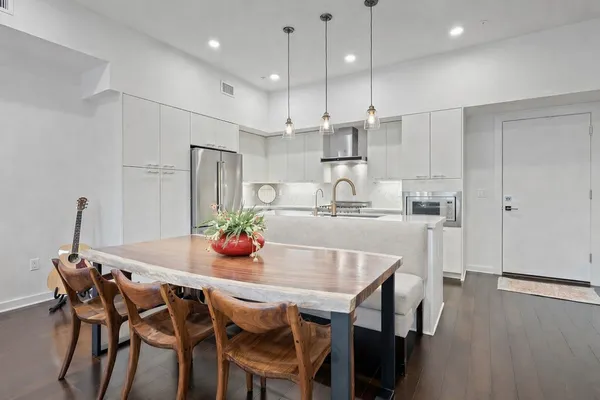 a kitchen with kitchen island a dining table and chairs
