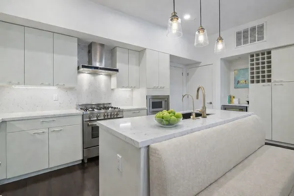 a kitchen with kitchen island white cabinets and refrigerator