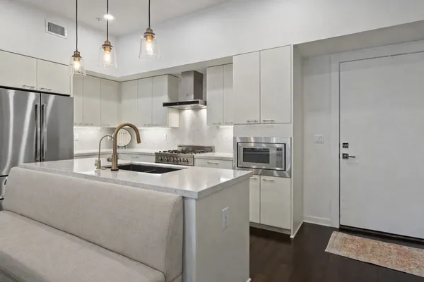a kitchen with stainless steel appliances granite countertop a sink and refrigerator