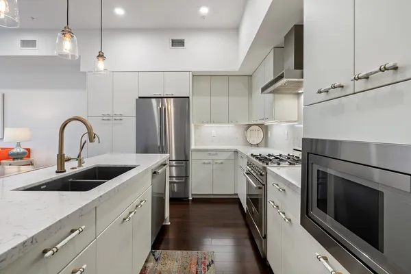 a kitchen with stainless steel appliances granite countertop a sink stove and refrigerator
