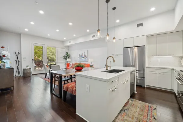 a kitchen that has a lot of cabinets a sink and appliances in it