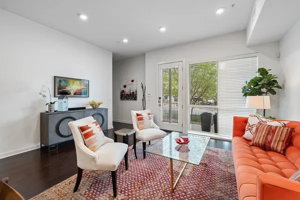 a living room with furniture and a floor to ceiling window
