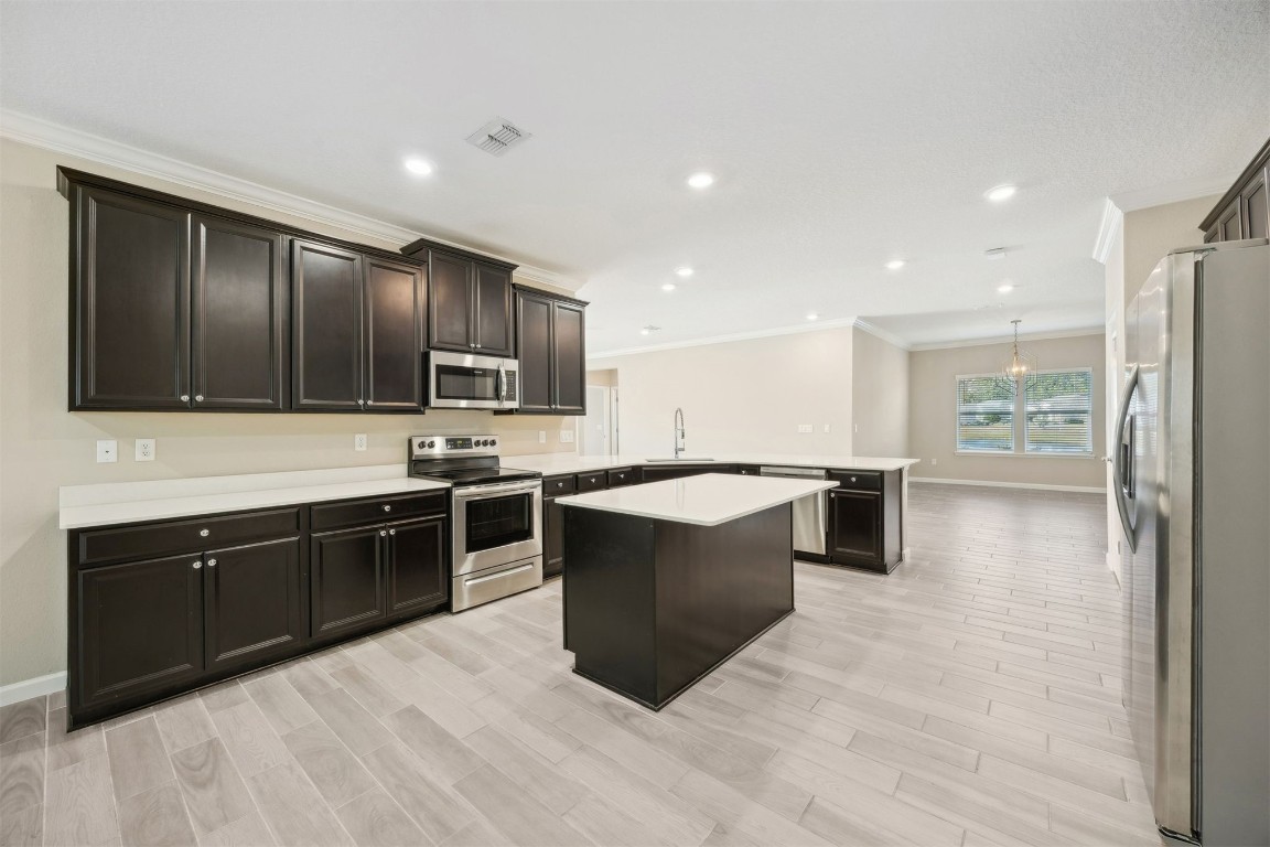 85237 Fall River Parkway Fernandina Beach, FL 32034 - Photo 3 of 82 a large kitchen with stainless steel appliances granite countertop a stove a sink dishwasher and a refrigerator with wooden floor