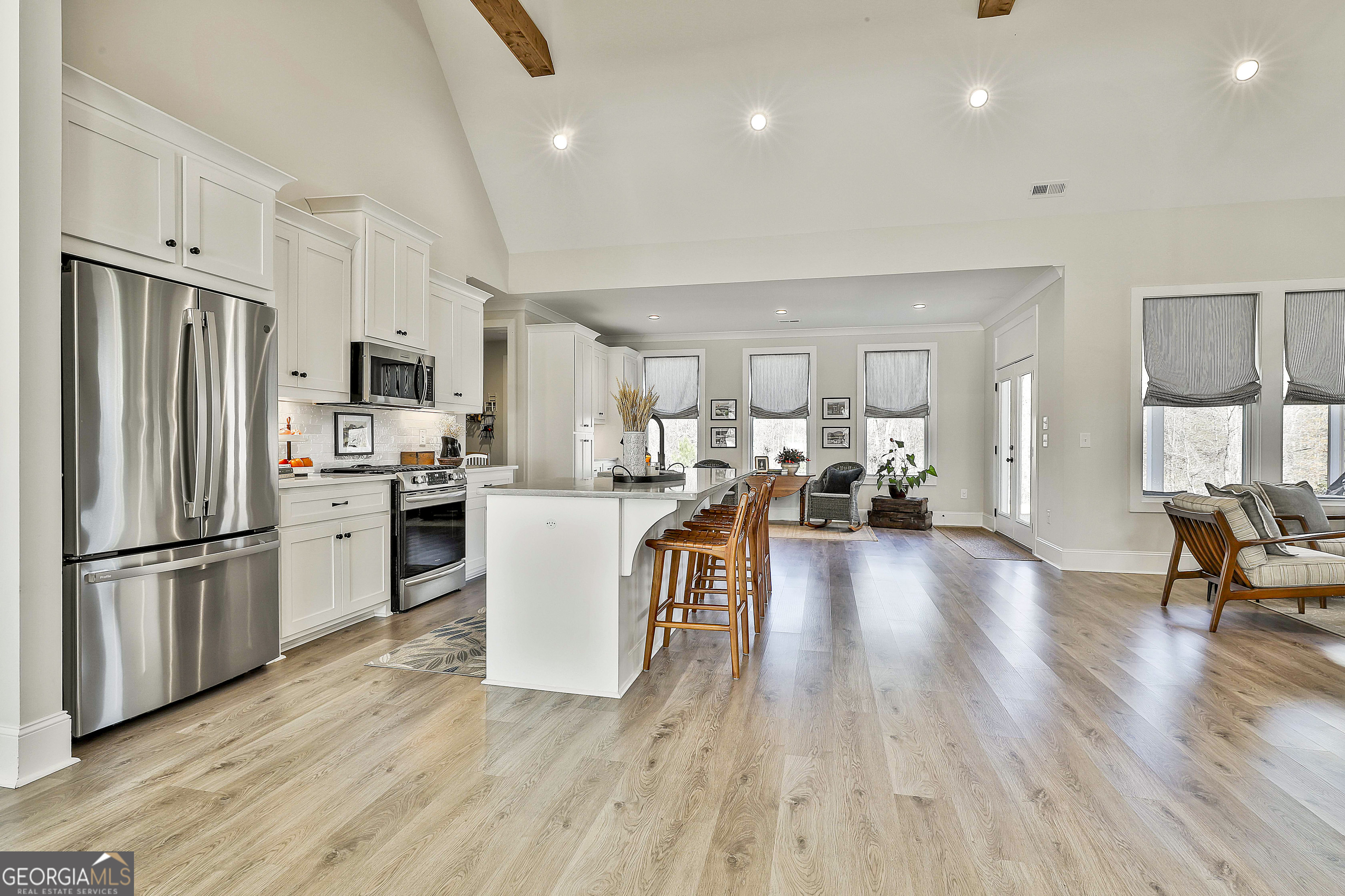 335 Werner Way Senoia, GA 30276 - Photo 15 of 51 a kitchen with a refrigerator a stove top oven a sink dishwasher a dining table and chairs with wooden floor