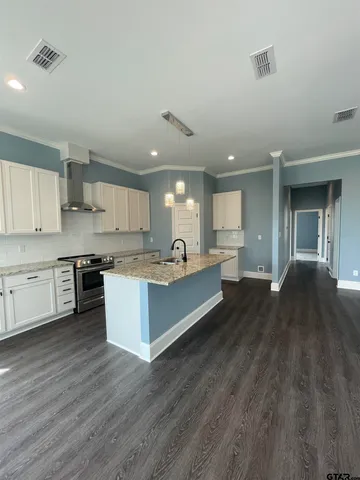 a large kitchen with stainless steel appliances kitchen island a large counter top and a stove