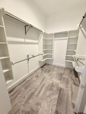 a view of walk in closet with empty racks