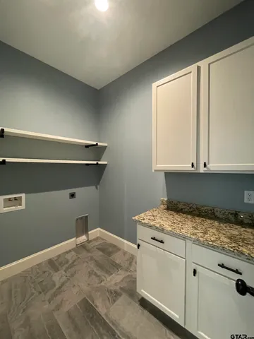 a view of an empty room with window and chandelier fan