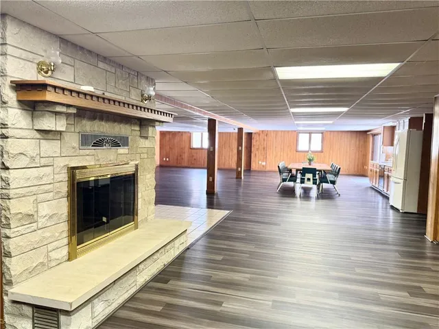 a kitchen with stainless steel appliances a dining table chairs refrigerator and cabinets