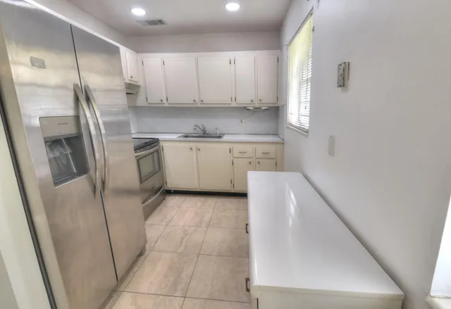 a kitchen with stainless steel appliances a refrigerator sink and cabinets