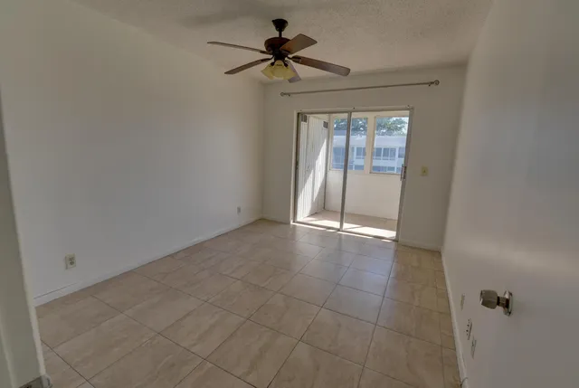 a view of an empty room and a ceiling fan window