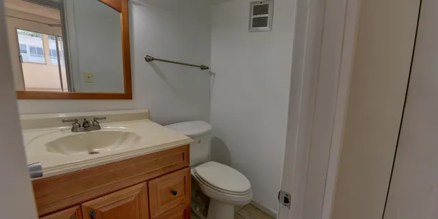 a bathroom with a sink toilet and mirror
