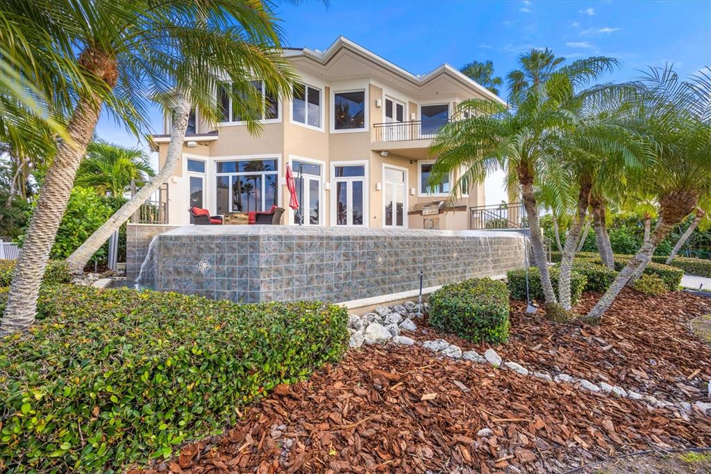 761 Norton Street Longboat Key, FL 34228 - Photo 60 of 66 a view of a white house with large windows and a yard