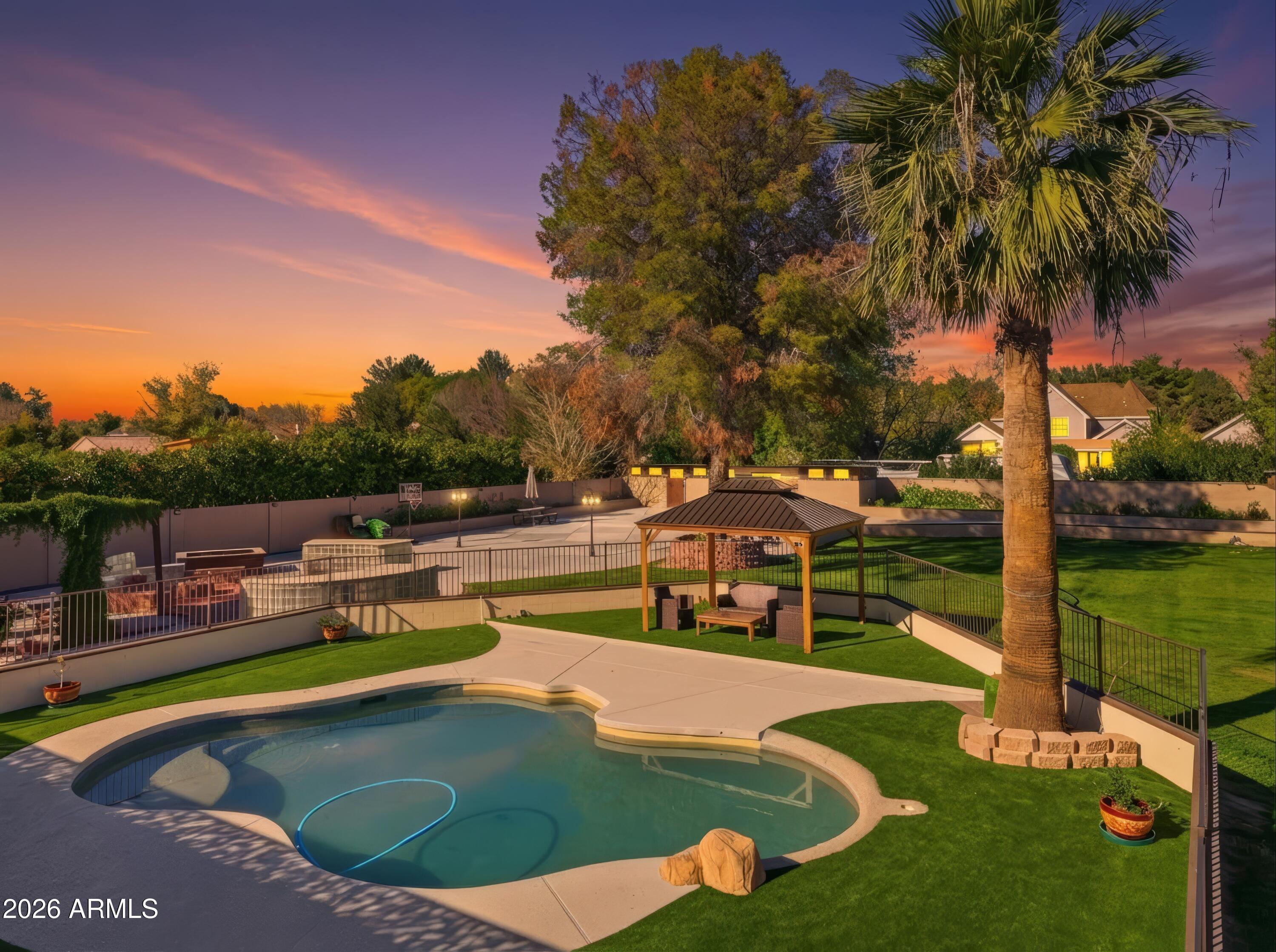 a view of a swimming pool with a lawn chairs under an umbrella