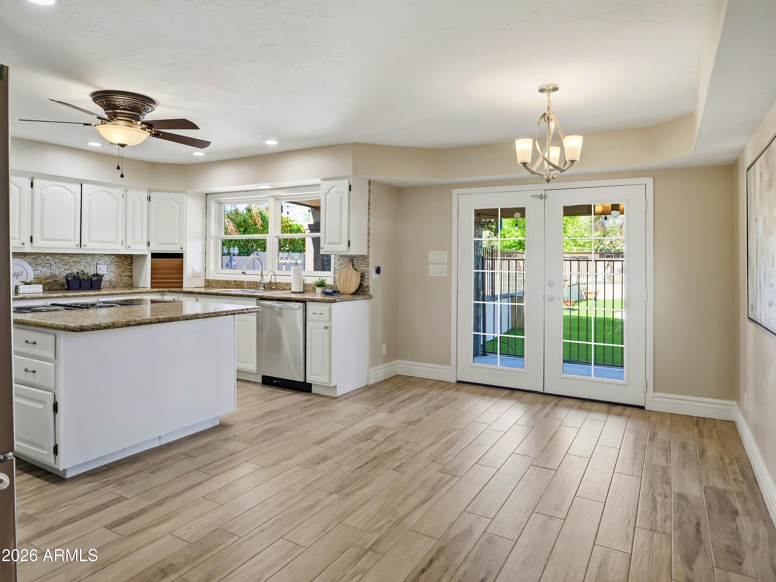 3154 East Inverness Avenue Mesa, AZ 85204 - Photo 14 of 70 a kitchen with stainless steel appliances granite countertop wooden floors and white cabinets
