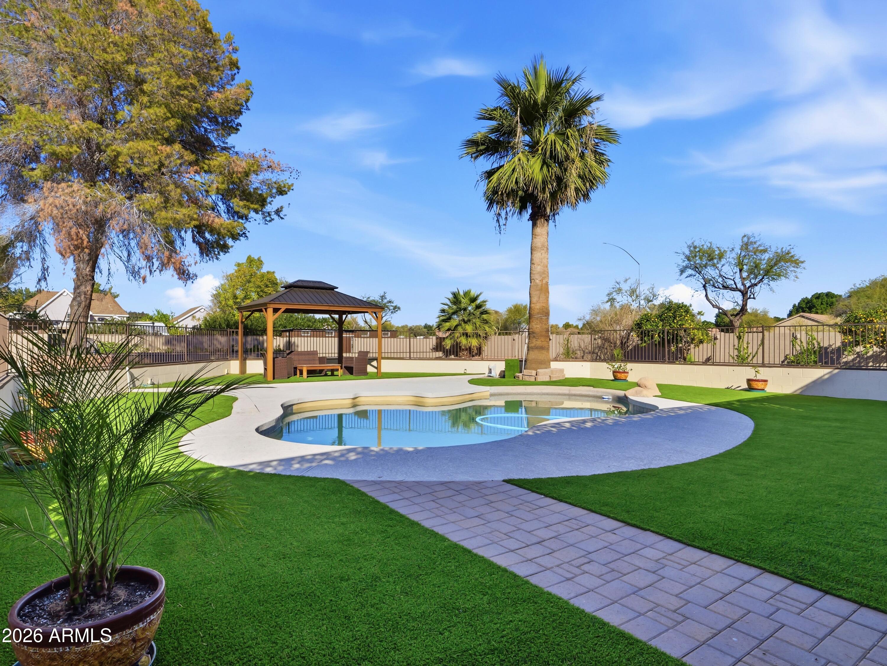 3154 East Inverness Avenue Mesa, AZ 85204 - Photo 25 of 70 a view of a swimming pool with a yard and palm trees