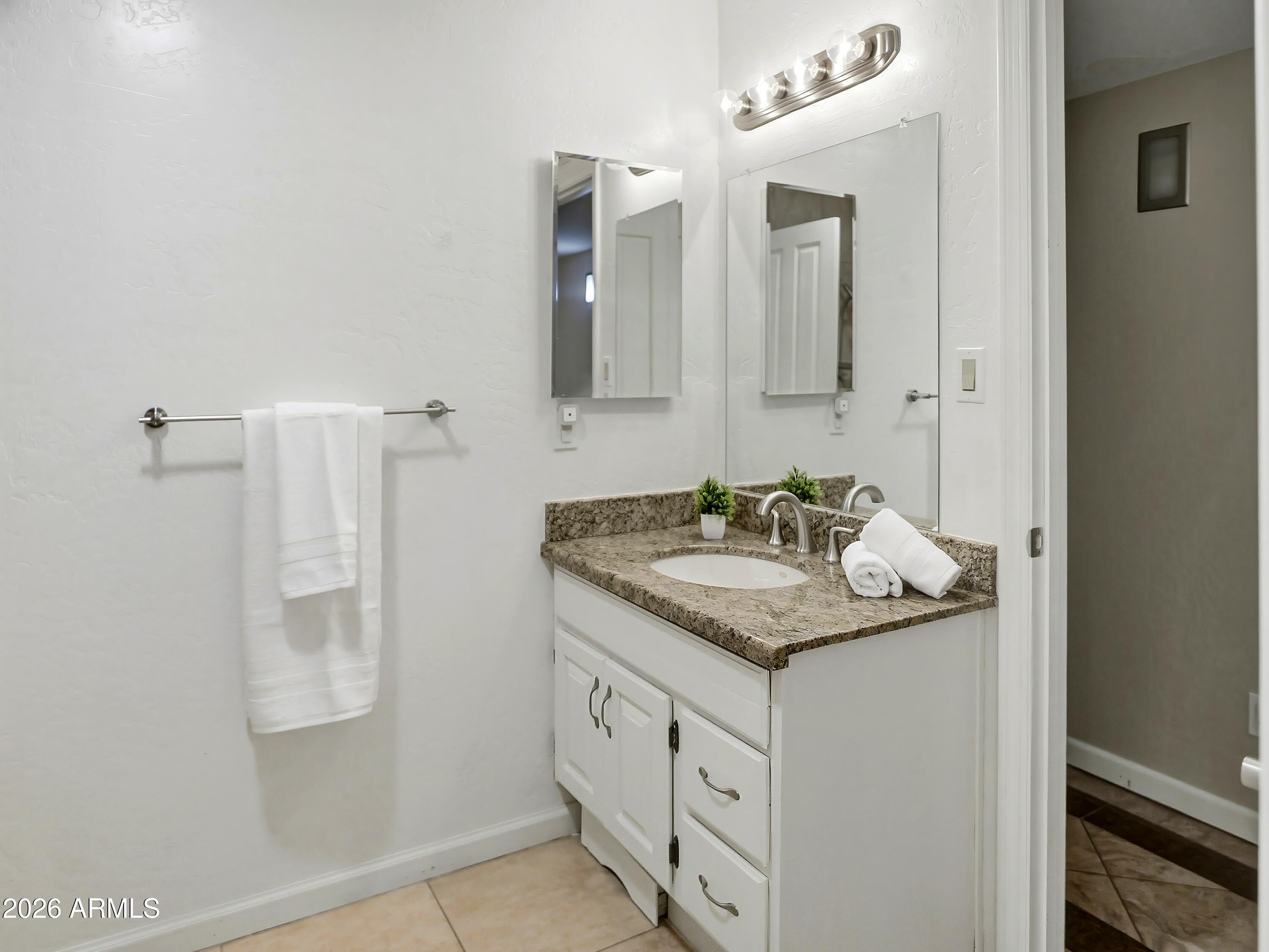 3154 East Inverness Avenue Mesa, AZ 85204 - Photo 45 of 70 a bathroom with a granite countertop sink and a mirror