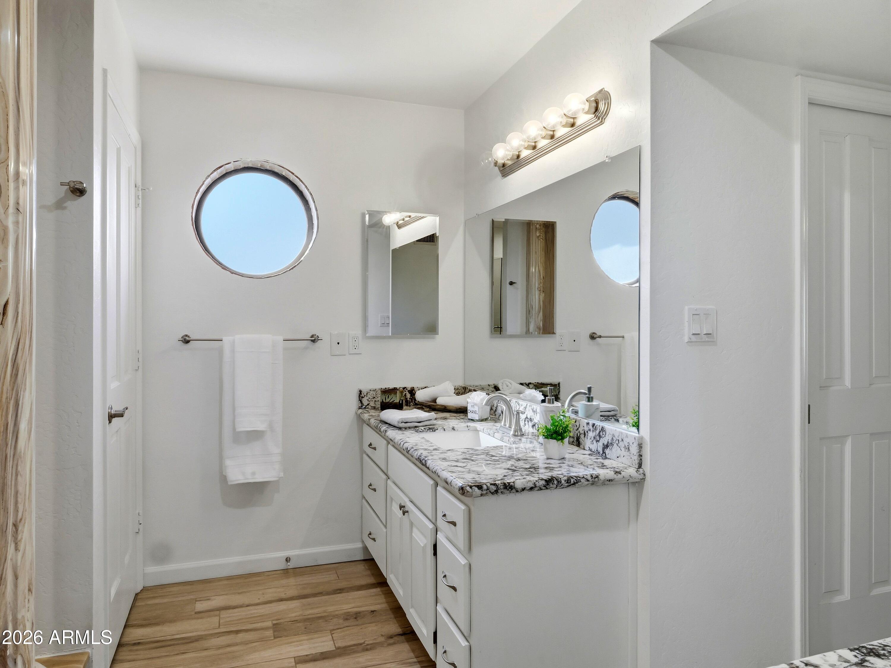 3154 East Inverness Avenue Mesa, AZ 85204 - Photo 56 of 70 a bathroom with a granite countertop sink a large mirror and a shower