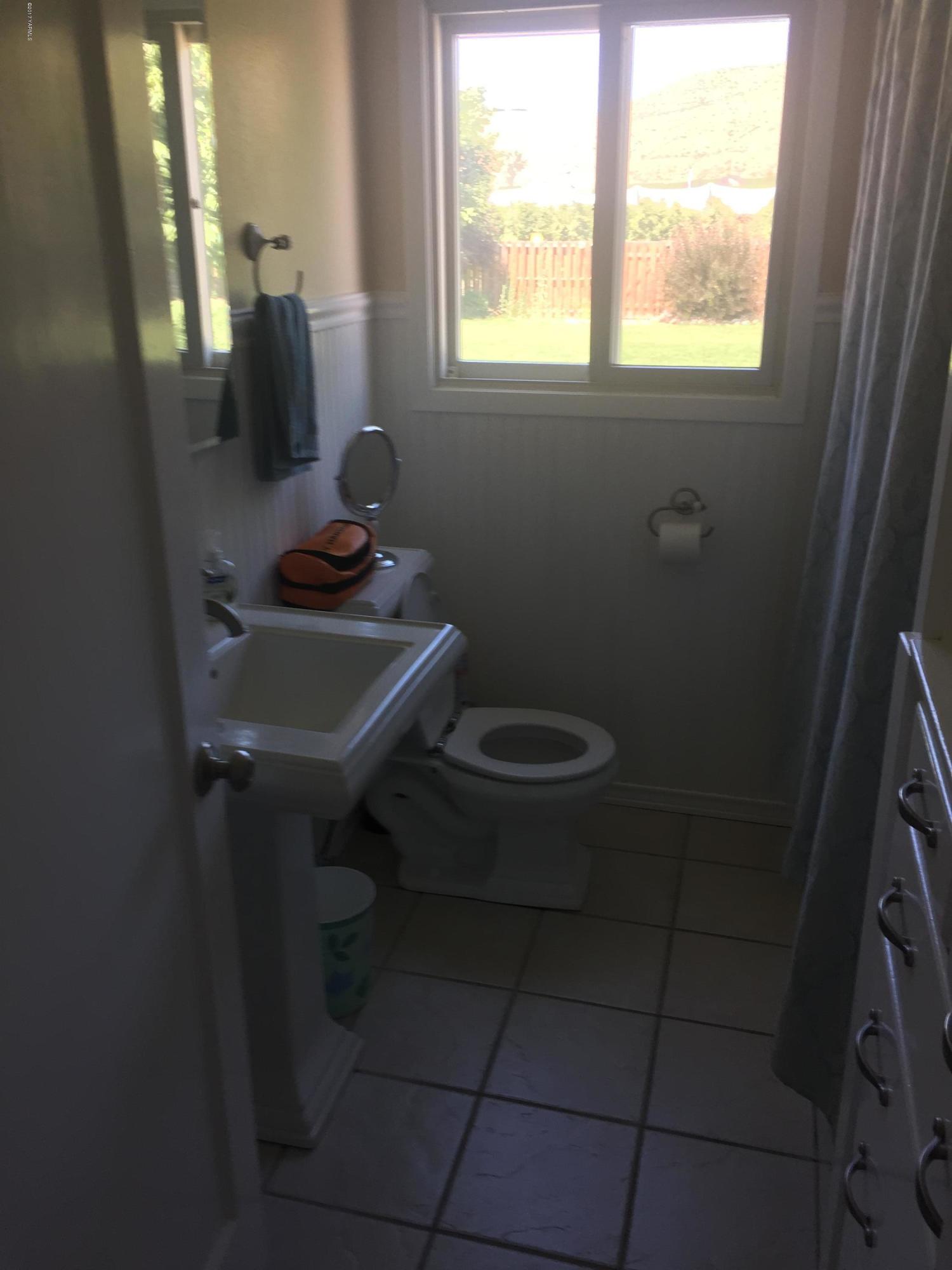 431 Allan Road Naches, WA 98937 - Photo 37 of 50 a bathroom with a toilet a sink a window and mirror