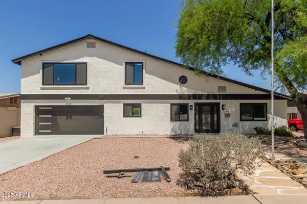 a view of a white house with a yard