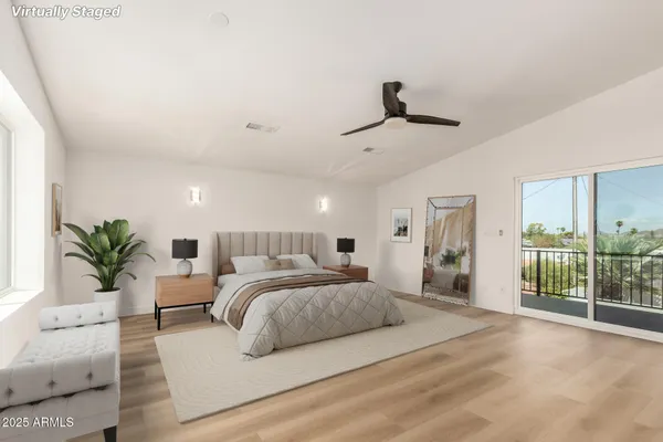 a spacious bedroom with a large bed and a chandelier