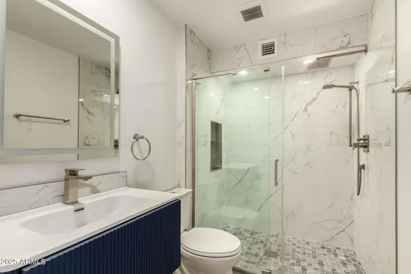 a bathroom with a sink toilet a mirror and shower